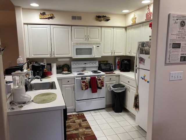 kitchen featuring white appliances, visible vents, light tile patterned flooring, a sink, and light countertops