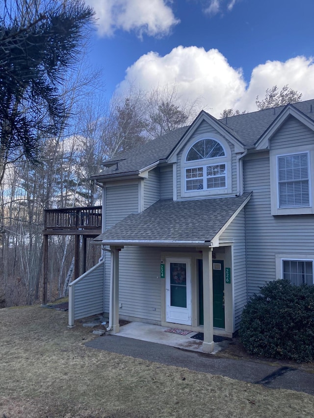 view of front of home featuring a wooden deck and a shingled roof