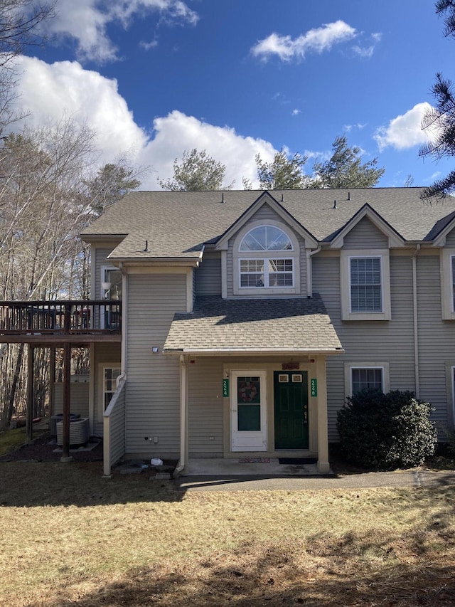 view of front of home featuring roof with shingles and a front yard