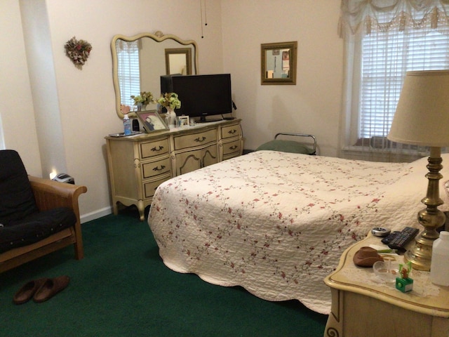 bedroom with baseboards and dark colored carpet