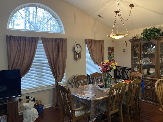 dining area featuring vaulted ceiling, wood finished floors, and visible vents