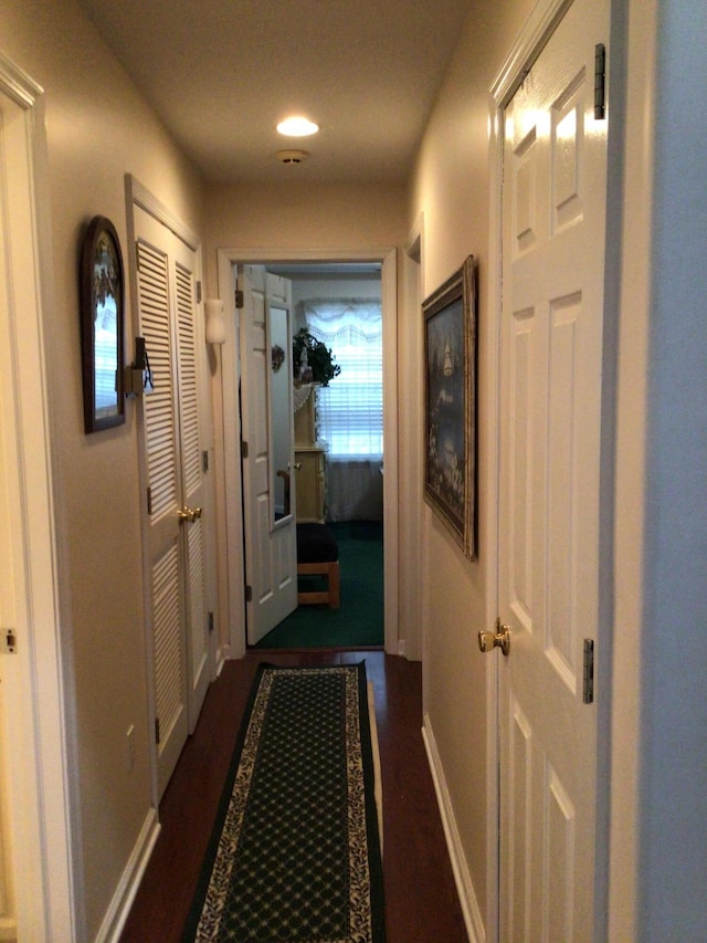 hall featuring baseboards and dark wood-style floors