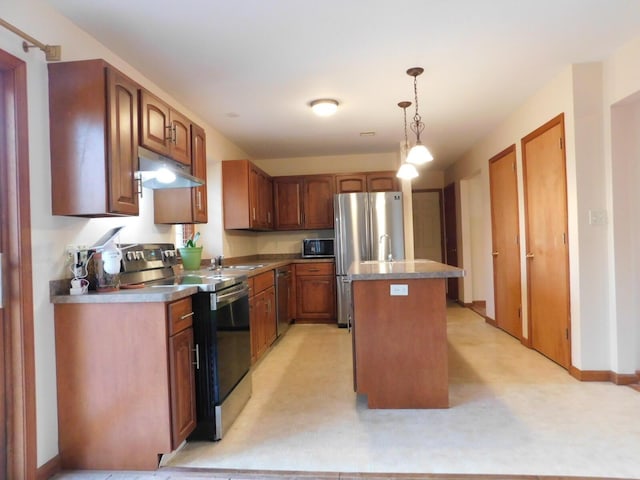 kitchen featuring baseboards, a center island with sink, stainless steel appliances, under cabinet range hood, and decorative light fixtures