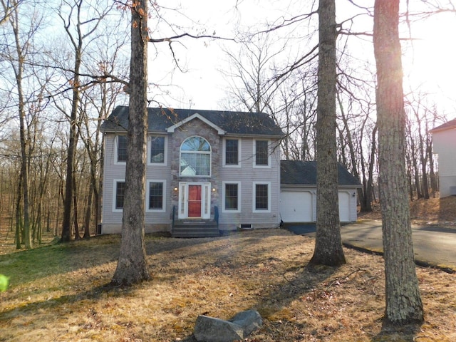 colonial inspired home featuring driveway and a garage