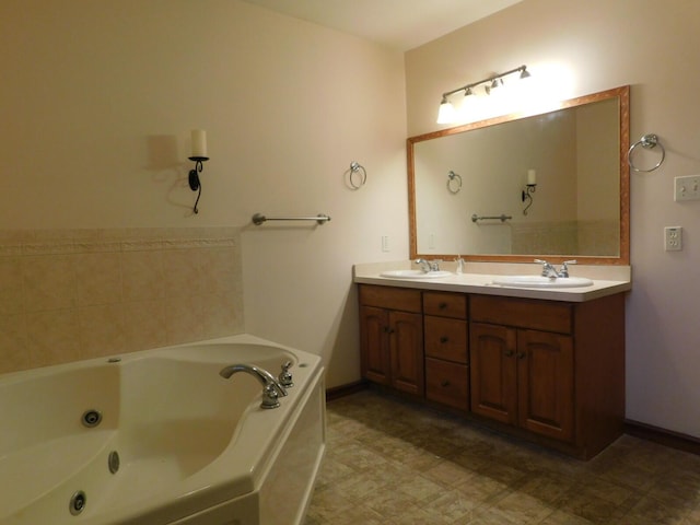 bathroom with double vanity, a tub with jets, baseboards, and a sink