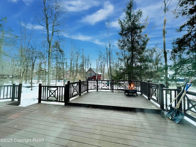 snow covered deck featuring an outdoor fire pit