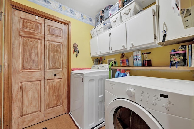 washroom featuring cabinet space and washer and clothes dryer