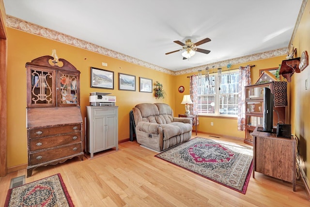 living area featuring visible vents, light wood-type flooring, and ceiling fan