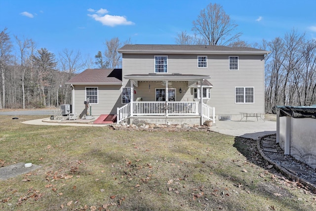 rear view of property featuring a yard, covered porch, cooling unit, and a patio area