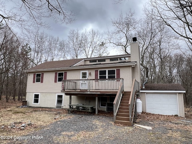 view of front of property with a garage, stairs, a chimney, and a deck