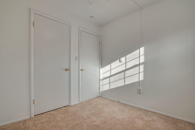 unfurnished bedroom with baseboards and carpet