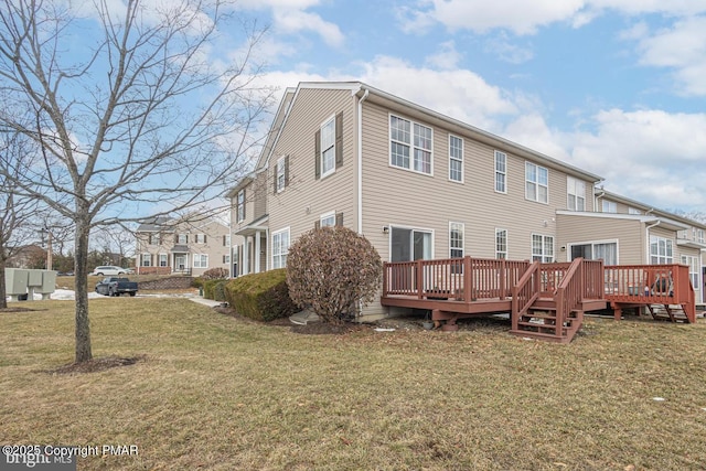 rear view of house with a yard and a deck