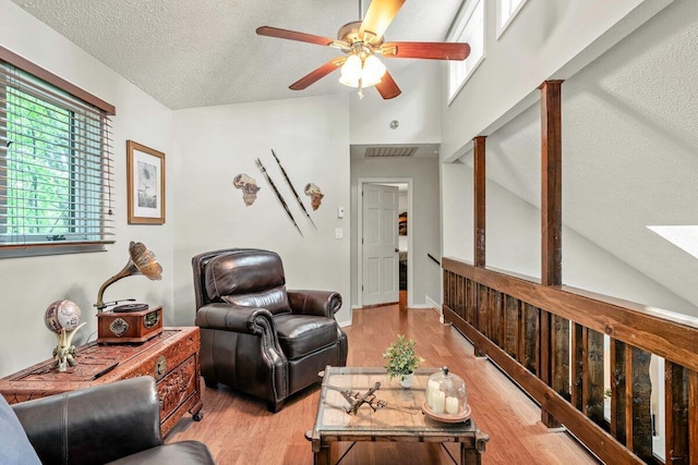 108 Bayberry Ct, Stroudsburg, PA 18360 - living room featuring light wood finished floors, a ceiling fan, a textured ceiling, and high vaulted ceiling