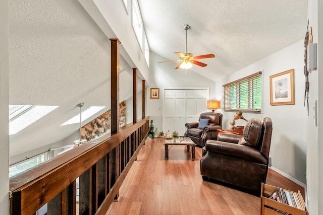108 Bayberry Ct, Stroudsburg, PA 18360 - living room featuring a textured ceiling, lofted ceiling, light wood-style flooring, a ceiling fan, and a skylight