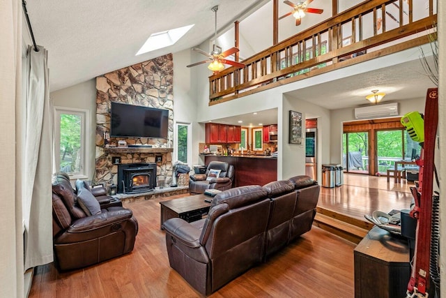 108 Bayberry Ct, Stroudsburg, PA 18360 - living room featuring ceiling fan, wood finished floors, a wall mounted AC, a skylight, and a stone fireplace