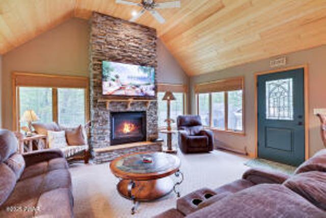 7 Shore Line Dr, Lakeville, PA 18438 - carpeted living area with wooden ceiling, vaulted ceiling, a fireplace, and a ceiling fan