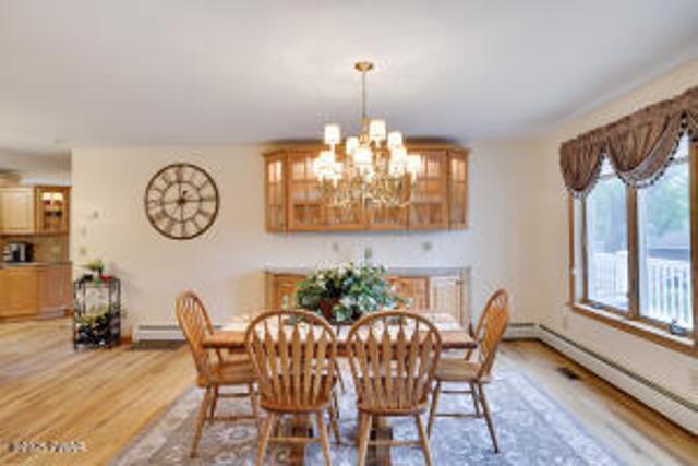 7 Shore Line Dr, Lakeville, PA 18438 - dining room with a baseboard heating unit, light wood finished floors, a chandelier, and baseboards