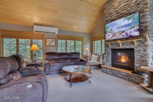 7 Shore Line Dr, Lakeville, PA 18438 - living room with a wall unit AC, wood ceiling, a fireplace, and high vaulted ceiling