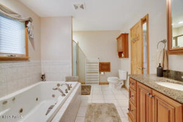 7 Shore Line Dr, Lakeville, PA 18438 - full bath featuring a whirlpool tub, vanity, tile patterned flooring, toilet, and a shower with door