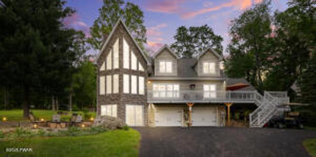 7 Shore Line Dr, Lakeville, PA 18438 - rear view of property with driveway, a garage, stairs, and a wooden deck