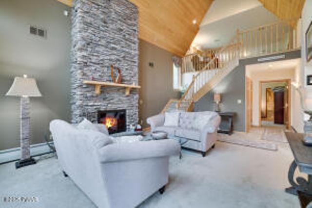 7 Shore Line Dr, Lakeville, PA 18438 - carpeted living area with stairway, a fireplace, and high vaulted ceiling
