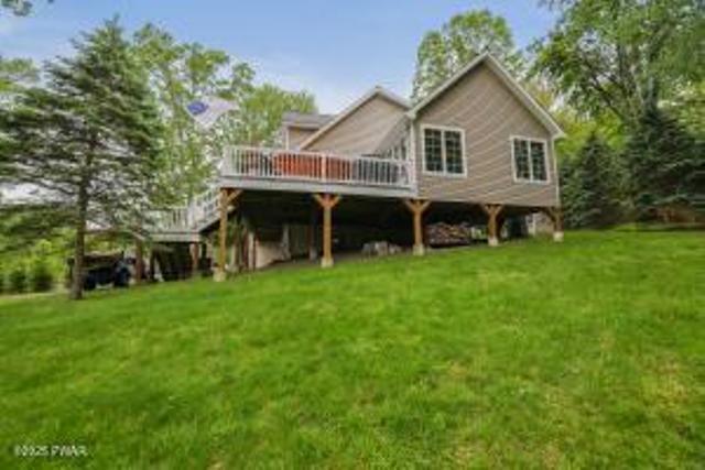 7 Shore Line Dr, Lakeville, PA 18438 - back of house with a wooden deck, a lawn, and stairs