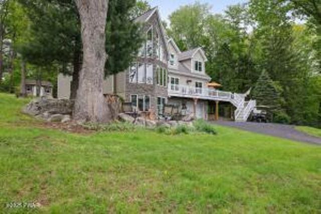 7 Shore Line Dr, Lakeville, PA 18438 - rear view of property featuring a wooden deck, a yard, a garage, and asphalt driveway