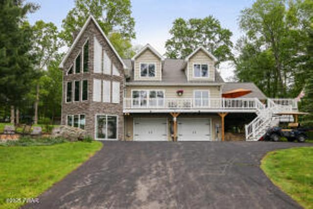7 Shore Line Dr, Lakeville, PA 18438 - view of front of property featuring a garage, driveway, a wooden deck, a front yard, and stairway