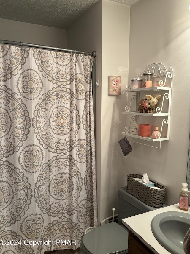 full bathroom featuring a shower with curtain, toilet, a textured ceiling, and vanity