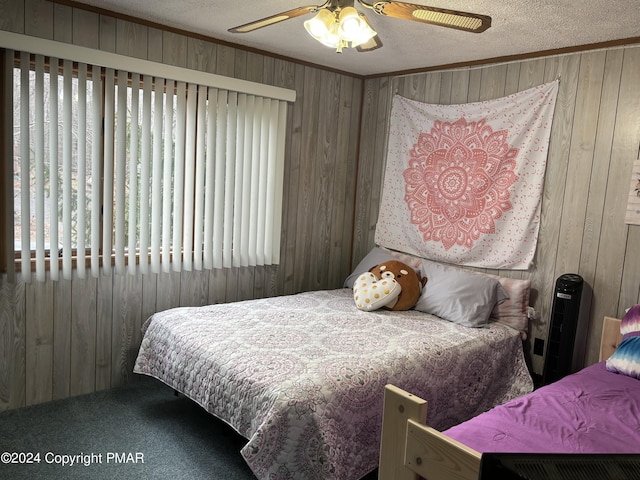 bedroom featuring a textured ceiling, carpet floors, ornamental molding, and wood walls