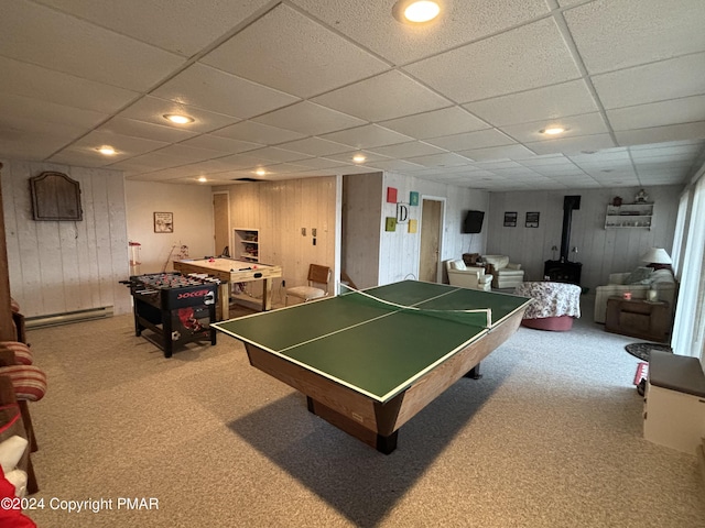 game room featuring a wood stove, carpet floors, a baseboard heating unit, and recessed lighting