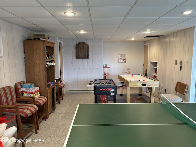 playroom featuring wood walls, carpet, baseboard heating, and a drop ceiling