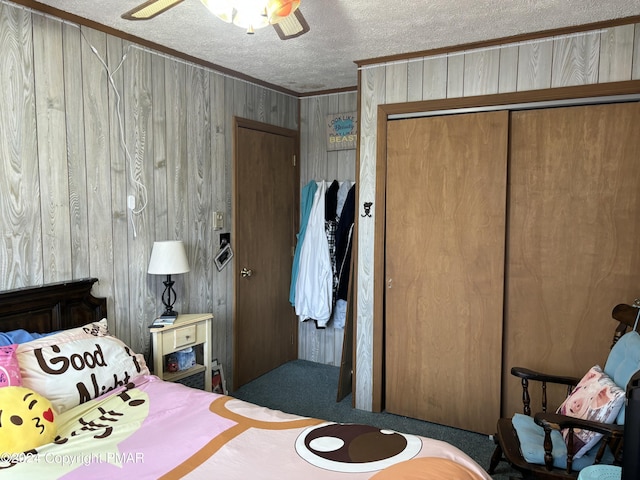 bedroom with ornamental molding, a closet, ceiling fan, and a textured ceiling