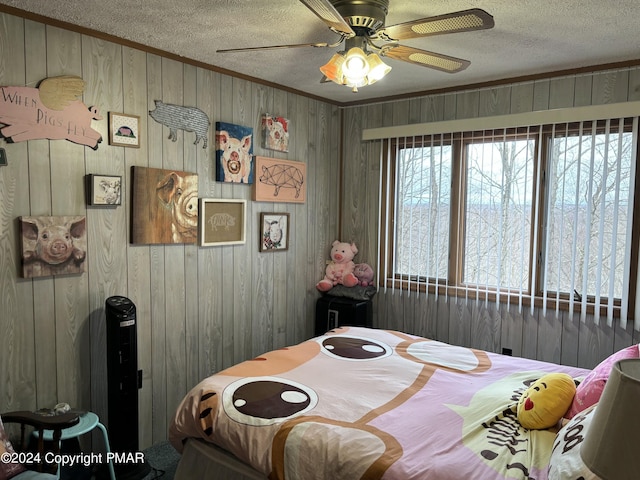 bedroom with a textured ceiling, ornamental molding, and a ceiling fan