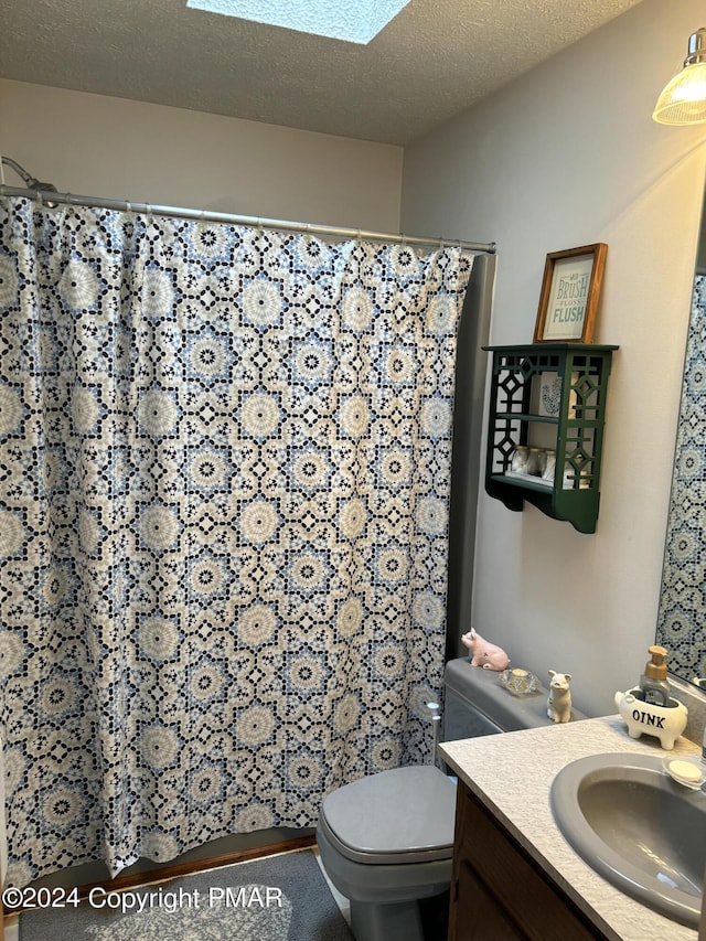 full bath featuring curtained shower, toilet, a textured ceiling, and vanity