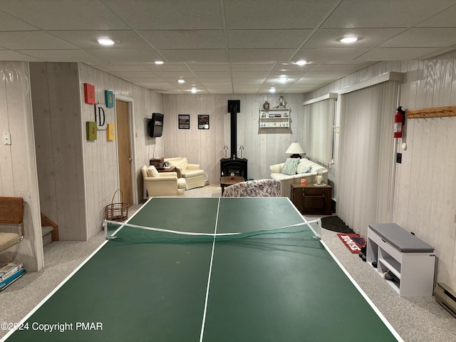 playroom with carpet floors, wooden walls, a wood stove, and recessed lighting