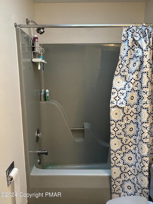 bathroom with shower / bath combination with curtain and toilet