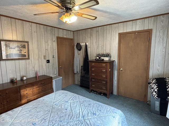 carpeted bedroom featuring a textured ceiling, ornamental molding, and a ceiling fan