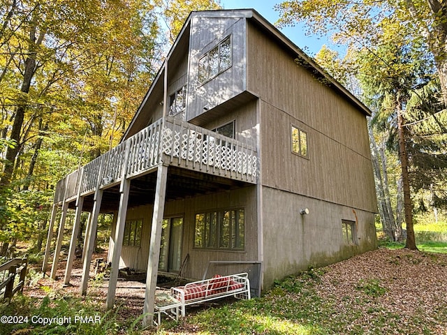 rear view of property featuring a wooden deck