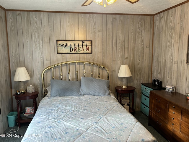 bedroom featuring carpet, ornamental molding, a ceiling fan, wood walls, and a textured ceiling