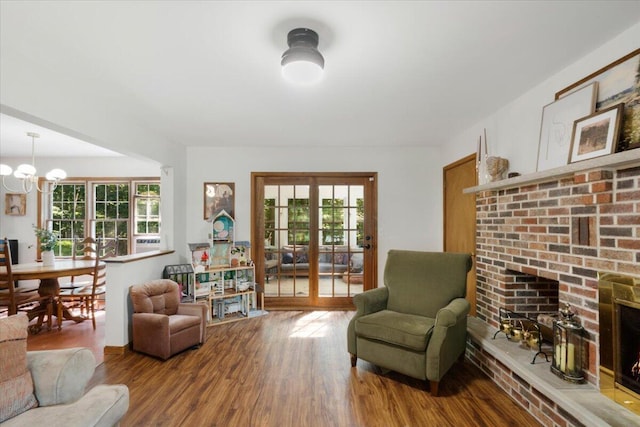 114 Gregory Ct, Stroudsburg, PA 18360 - living area featuring a brick fireplace, a chandelier, and wood finished floors