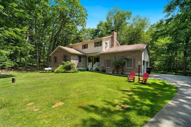 114 Gregory Ct, Stroudsburg, PA 18360 - view of front facade featuring a chimney, asphalt driveway, a front lawn, and brick siding