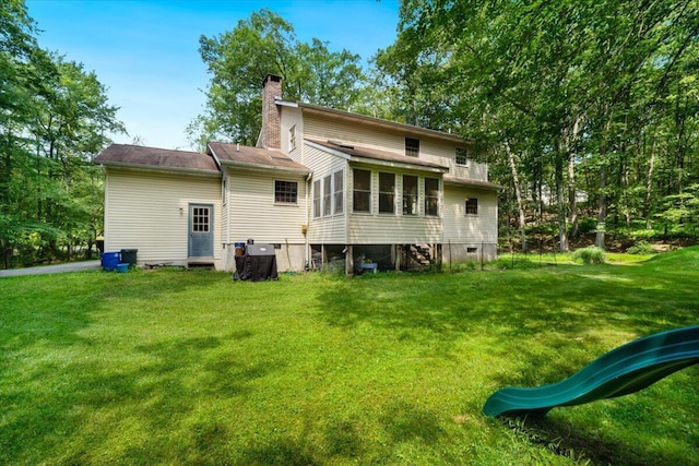 114 Gregory Ct, Stroudsburg, PA 18360 - back of property with a chimney, a yard, and a sunroom