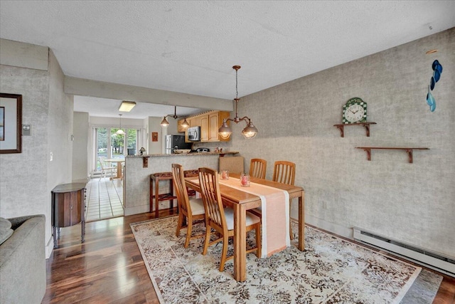 1055 Crestwoods Dr, Pocono Pines, PA 18350 - dining area featuring a baseboard heating unit, wood finished floors, and a textured ceiling