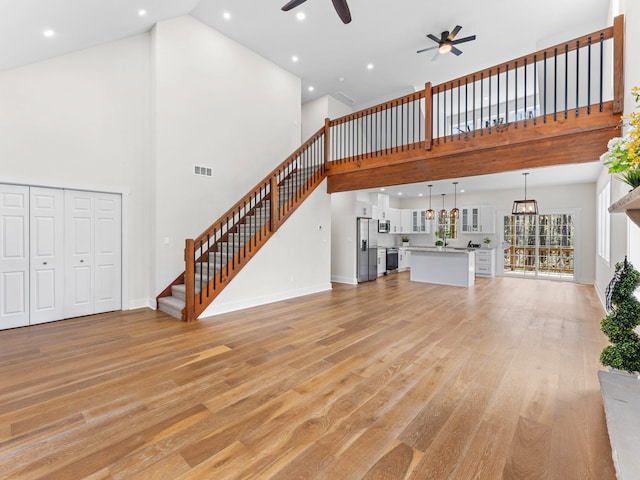 26 Susquehanna Dr, Jim Thorpe, PA 18229 - unfurnished living room with a ceiling fan, high vaulted ceiling, light wood-style flooring, stairs, and recessed lighting