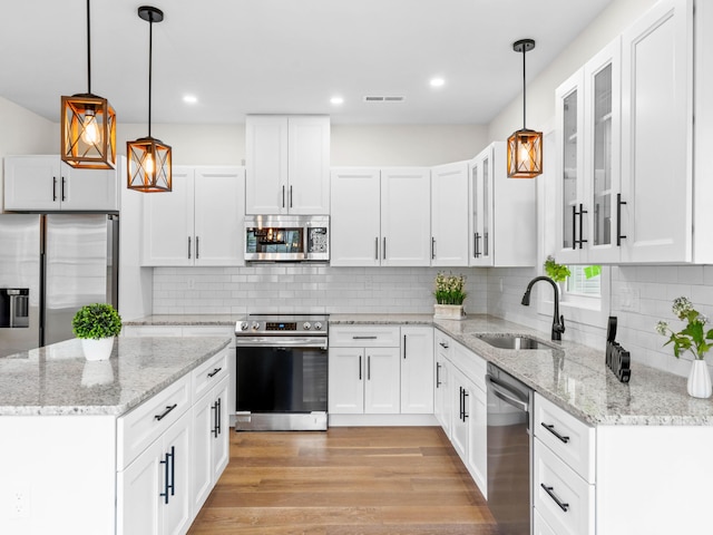 26 Susquehanna Dr, Jim Thorpe, PA 18229 - kitchen featuring appliances with stainless steel finishes, glass insert cabinets, white cabinetry, tasteful backsplash, and light wood-style flooring