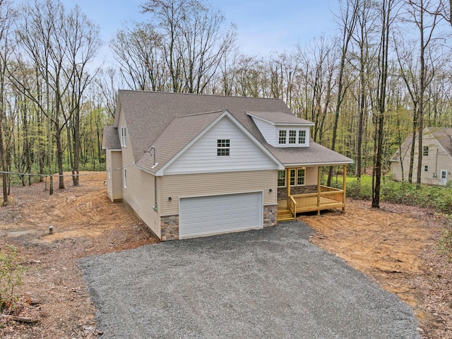 26 Susquehanna Dr, Jim Thorpe, PA 18229 - view of front of home featuring stone siding, a porch, a shingled roof, gravel driveway, and a garage
