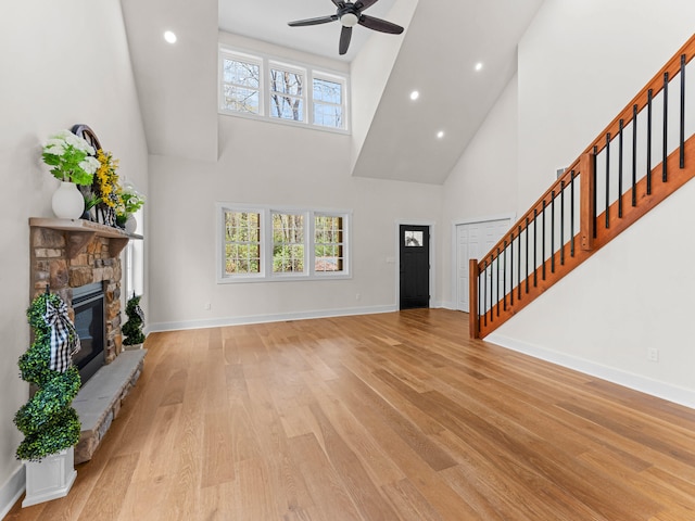 26 Susquehanna Dr, Jim Thorpe, PA 18229 - unfurnished living room with high vaulted ceiling, stairway, a fireplace, light wood-type flooring, and a ceiling fan