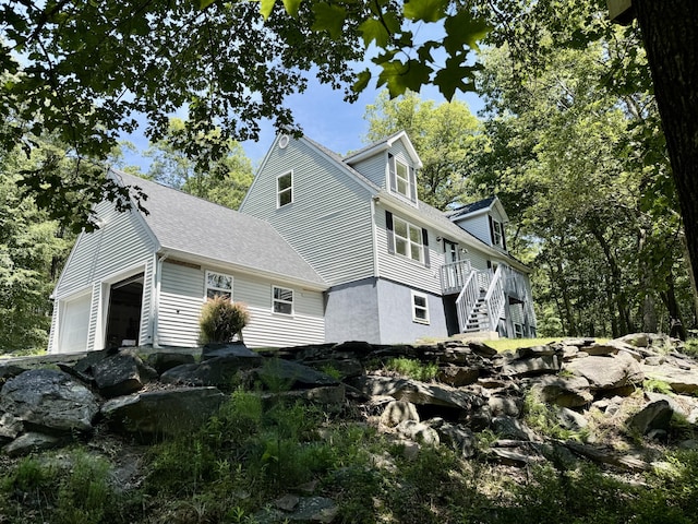 459 Pocono Blvd, Bushkill, PA 18324 - view of property exterior with an attached garage, stairway, and roof with shingles