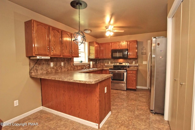 158 Davis Cir, Bushkill, PA 18324 - kitchen with stainless steel appliances, a peninsula, decorative backsplash, and brown cabinetry